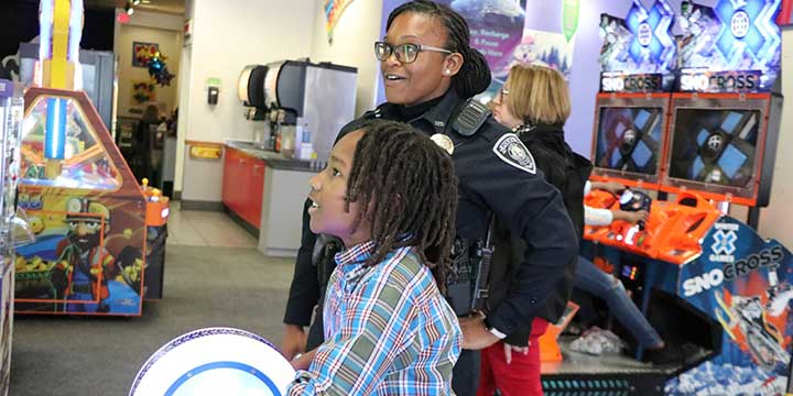 Sumter Police Officer playing in arcade with a kid