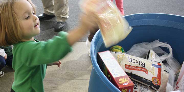 Small child donating to food drive