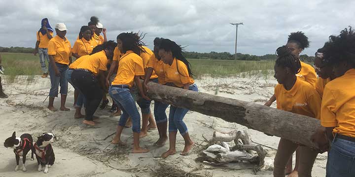 Image of Youth Corps members lifting a large log